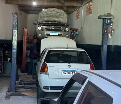 Carro no elevador durante serviço na LUANs Oficina Mecânica